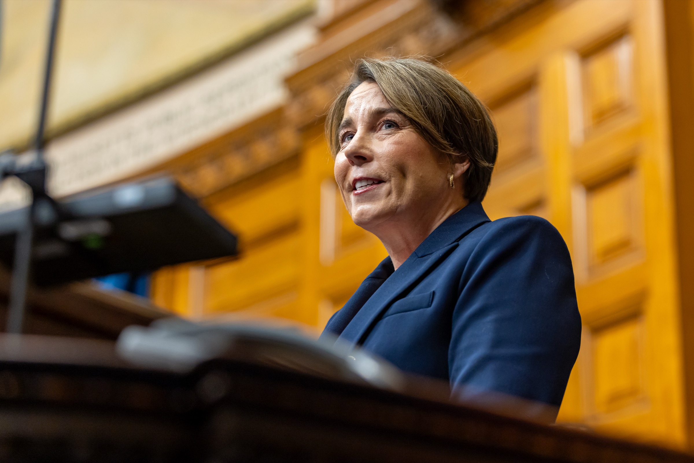 Governor Maura Healey speaking from the rostrum in the Massachusetts House chamber